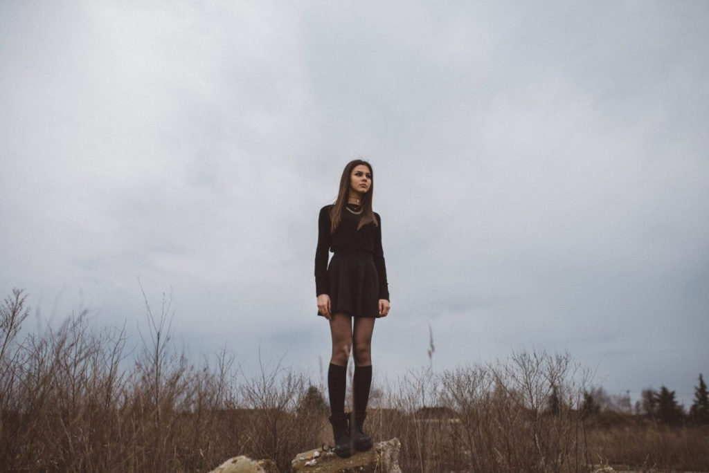 girl standing on rock in meadow